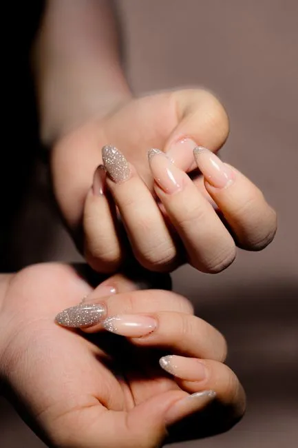 Almond shaped nails in a nude shade with a shimmer finish